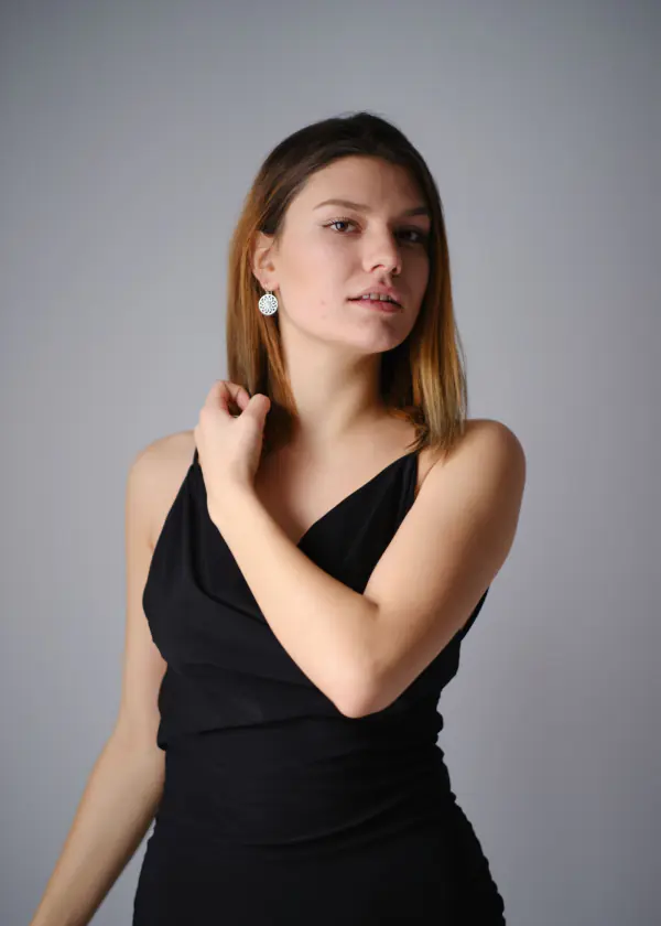Woman in a black dress with silver earrings