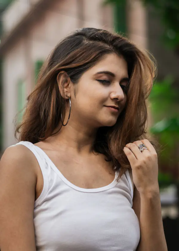 Woman in a white top with jewelry